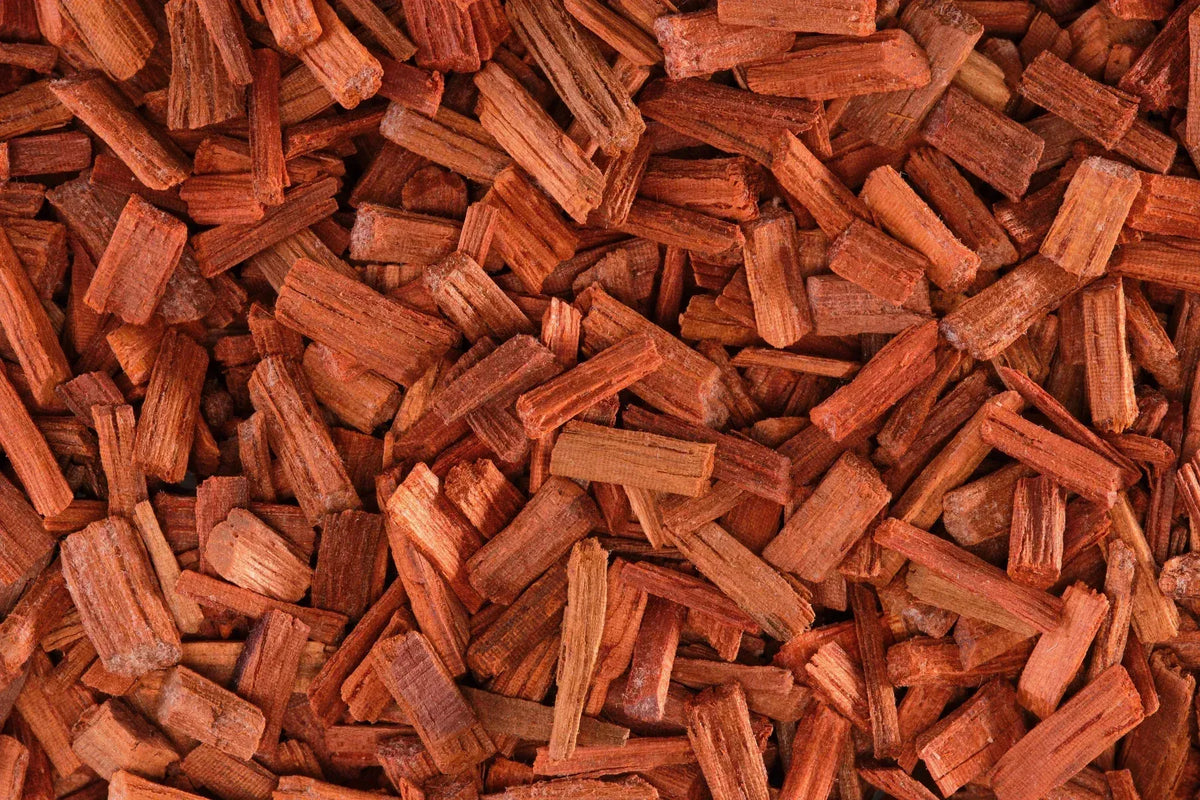 Close-up of reddish-brown sandalwood chips showing rough texture and natural wood grain