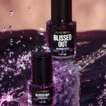 Blissed Out Balancing Face Oil 50 ml and 20 ml bottles in purple water display
