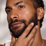 Model massaging facial oil into the beard and skin as part of a skincare routine