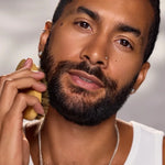 Model grooming his beard with a beard brush for a healthy, well-conditioned beard