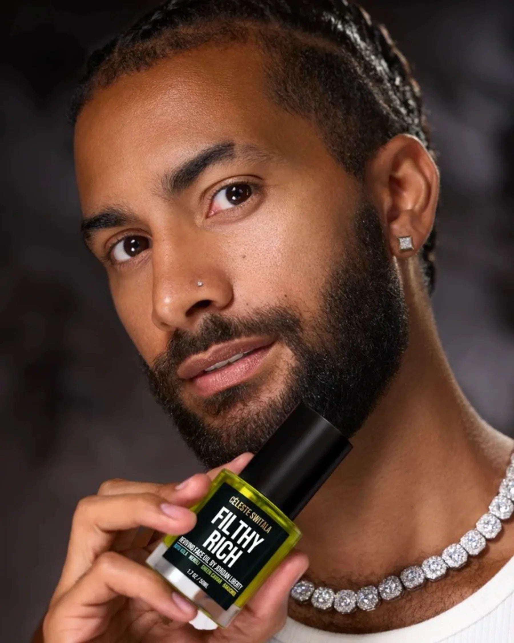 Man holding Céleste Switala Filthy Rich Reviving Face Oil beside his face