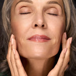 Woman touching her face with radiant moisturized-looking skin for Filthy Rich Face Oil