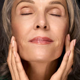 Woman touching her face with radiant moisturized-looking skin for Filthy Rich Face Oil