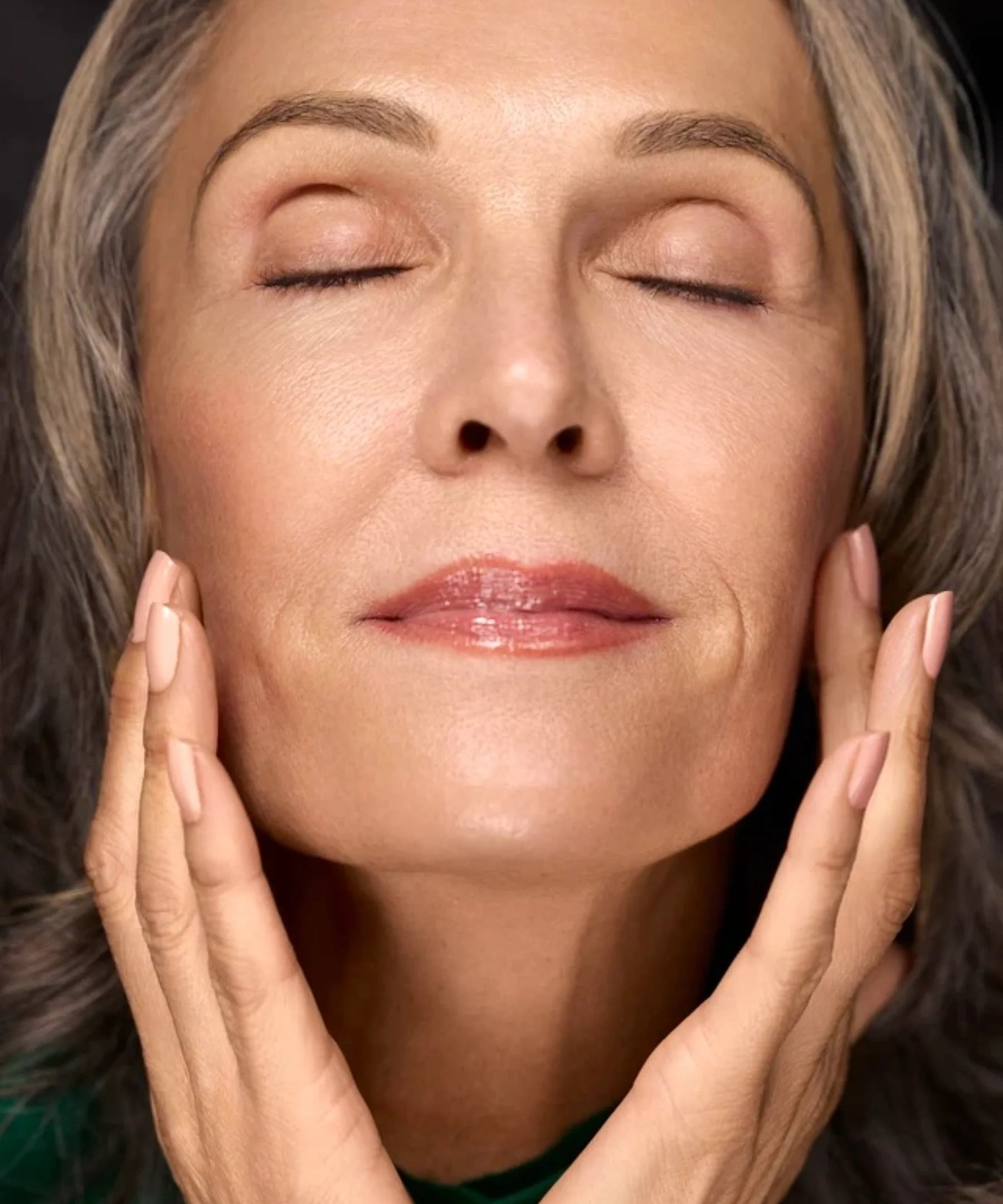 Woman touching her face with radiant moisturized-looking skin for Filthy Rich Face Oil