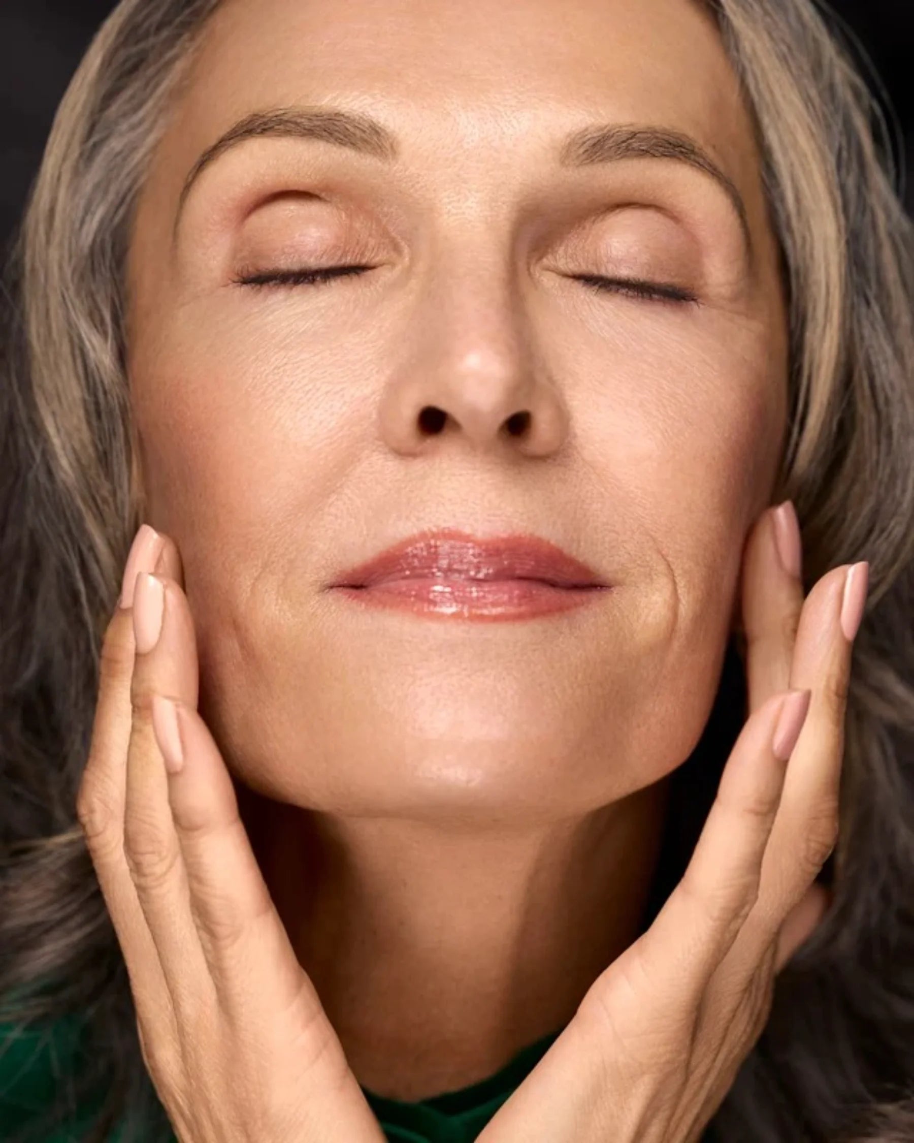 Woman touching her face with radiant moisturized-looking skin for Filthy Rich Face Oil