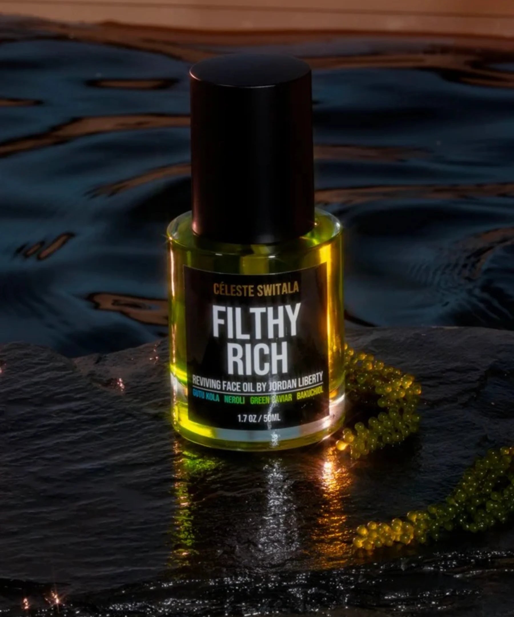 Filthy Rich Reviving Face Oil bottle photographed on a dark reflective luxury set