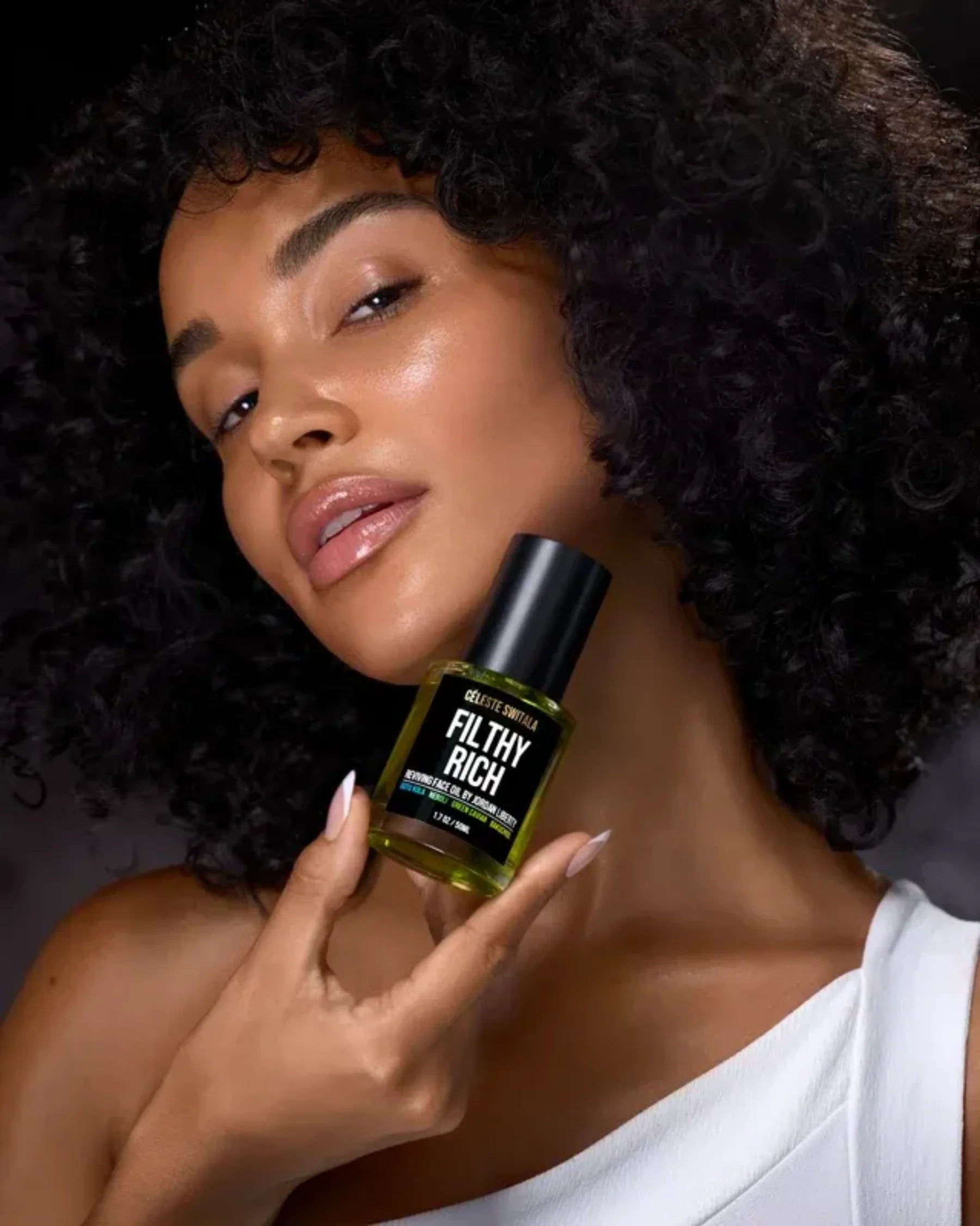 Model holding Filthy Rich Reviving Face Oil by Céleste Switala