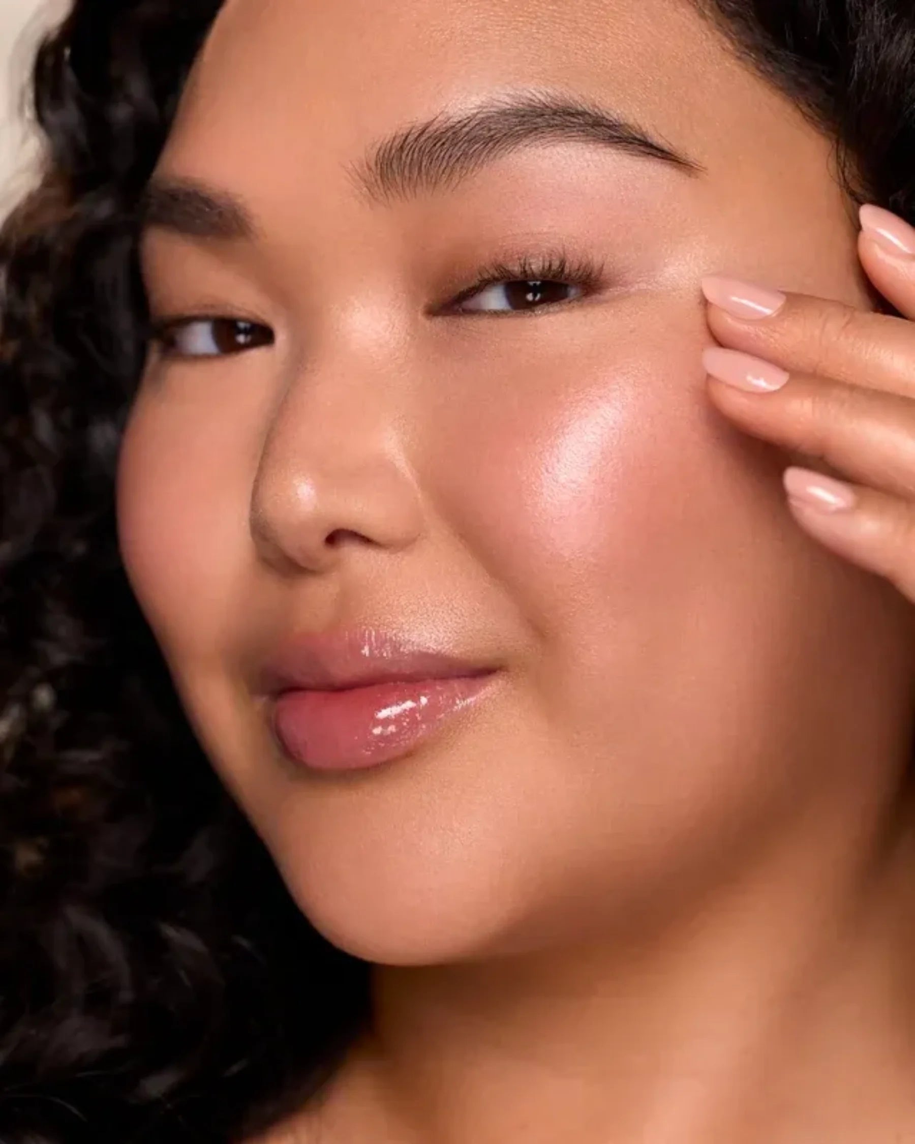 Woman with luminous glowing skin showcasing Infinite Icon Nourishing Face Oil skincare results